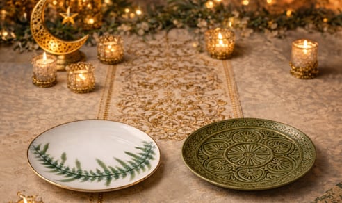 Minimal tableware set with plates, bowls, and glassware arranged on a dining table.
